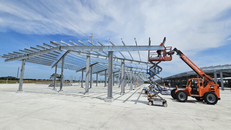 Lamar CISD Transportation Center Bus Canopies in Rosenberg TX - canopy framing during construction with telehandler lift, Keeton Construction Services