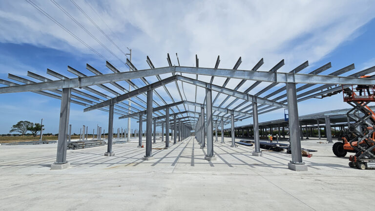 Lamar CISD Transportation Center Bus Canopies in Rosenberg TX - view along canopy framing during construction with scissor lift, Keeton Construction Services