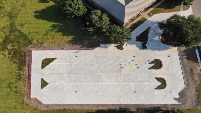 Overhead view of parking striping, directional arrows, ADA accessible stalls and curbed landscape islands on the new concrete lot